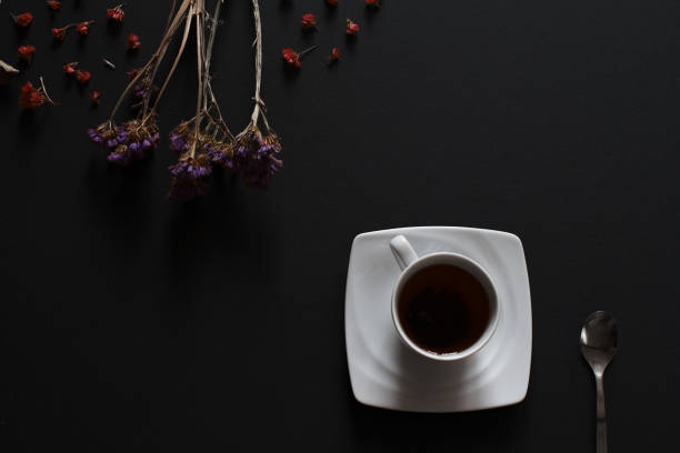 Abstract home background. Cup with flowers on a dark background with space for text.