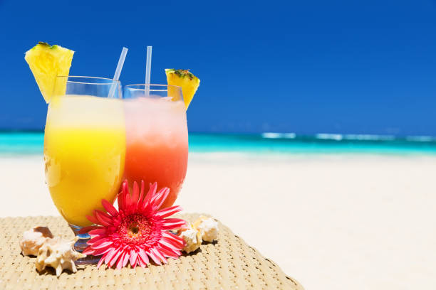 istock Two tropical fresh juices on white sandy beach 810082014
