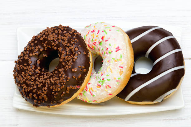 istock Tasty donuts with icing and chocolate on white wooden background, copy space 810099806