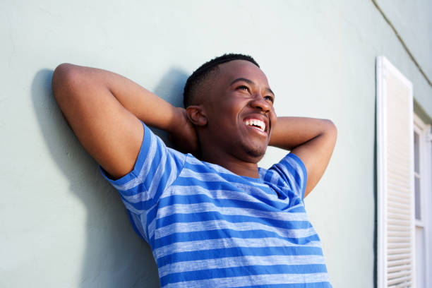 istock happy young african man smiling with hands behind head 810099850
