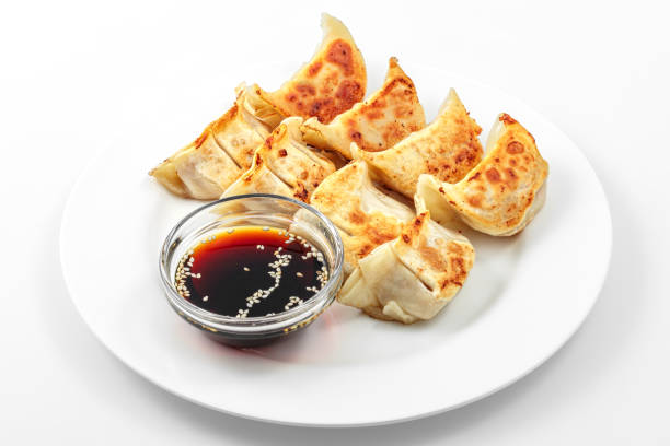 Ebi gedza hot dish, soy sauce, Japanese fried dumplings Ebi gedza hot dish, soy sauce, Japanese fried dumplings in white plate on  white background vianden stock pictures, royalty-free photos & images