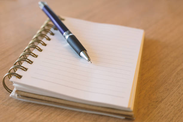 istock Blank notebook with pen on wooden desk 810114052