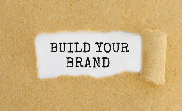 istock Text Build Your Brand appearing behind ripped brown paper. 810155848
