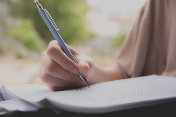 istock Woman sitting and holding a blue pencil and doing an exam 810161906