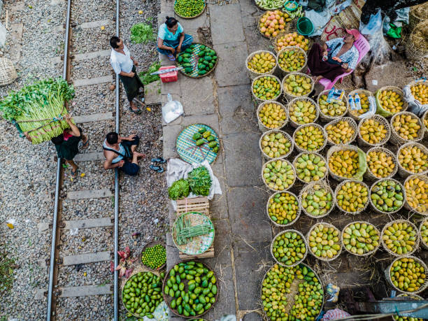 People selling goods at Danyingon station market Yangon Myanmar. This is a very large market that is known because some stall are on the rail tracks and vendors have to move away every time a train approaches the station. The market is mostly intended as a wholesale market where many vendors of the city come to sell the products in the city