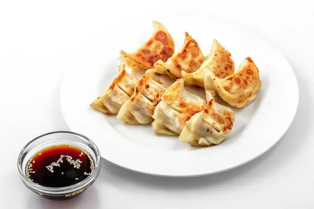 Ebi gedza hot dish, soy sauce, Japanese fried dumplings in white plate on  white background