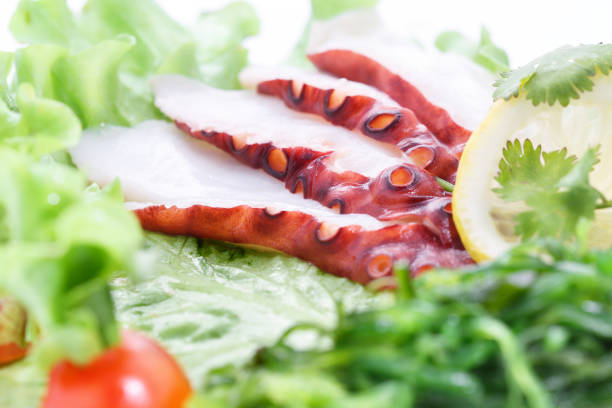 Sashimi octopus, vegetables, lettuce, tomato, octopus Sashimi octopus, vegetables, lettuce, tomato, octopus on white background salmon and red snapper stock pictures, royalty-free photos & images