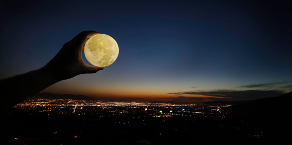 Man holding moon over Salt Lake City with Fireworks