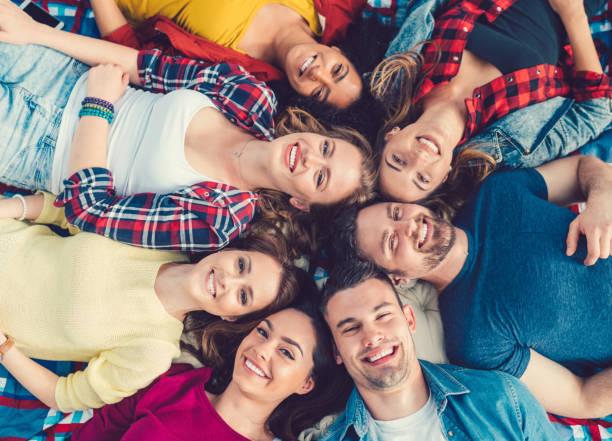 istock Friends lying on ground and smiling to the camera 810186046