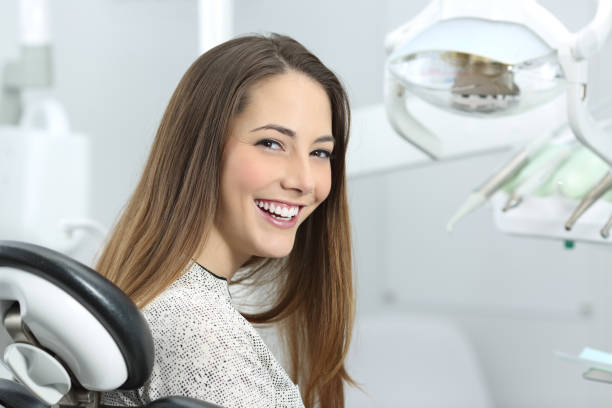 dentist patient showing perfect smile after treatment - human teeth whitening dentist smiling imagens e fotografias de stock