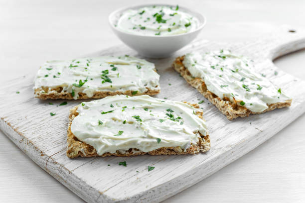 toast croccante fatto in casa con crema di formaggio e prezzemolo su sfondo lavagna di legno bianco. - crostini bruschetta antipasto appetizer foto e immagini stock