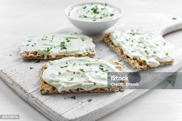 Homemade Crispbread Toast With Cream Cheese And Parsley On White Wooden Board Background Stock Photo - Download Image Now