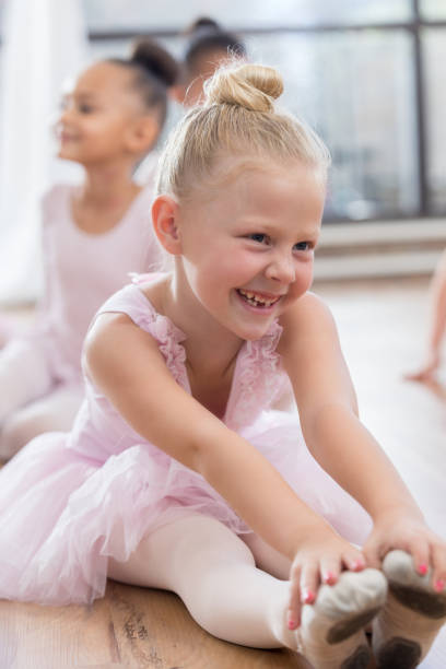 istock Young ballerina sits and touches her toes 810242834