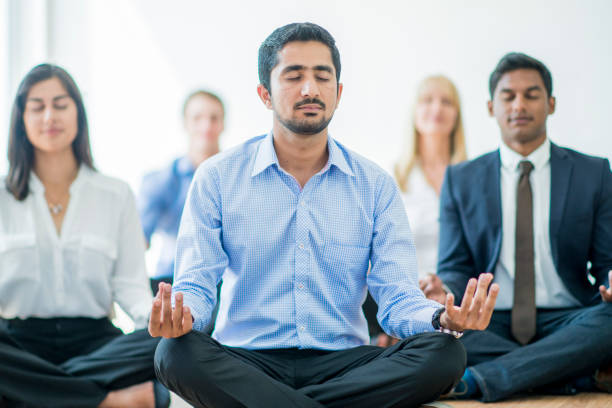 meditating at work - yoga meditating business group of people imagens e fotografias de stock