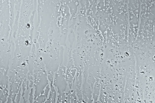 istock Rain drops on window glasses background. Natural Pattern of raindrops isolated on gray background. 810249900