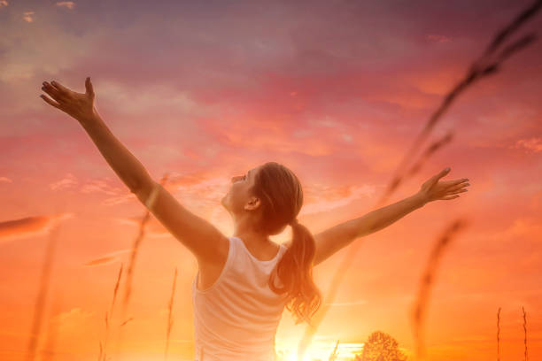 Free and happy woman against the sunset sky stock photo