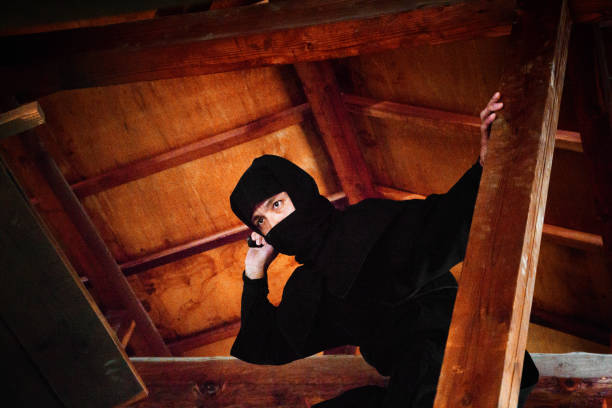 ninja japonais en costume noir cachant de grenier en bois prête à l’attaque - crime scene photos et images de collection