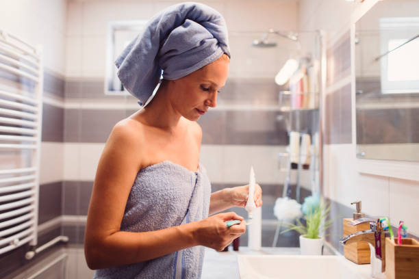 istock Woman brushing teeth in bathroom 810288062