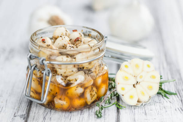 istock Garlic (preserved) on wooden background (selective focus) 810288356