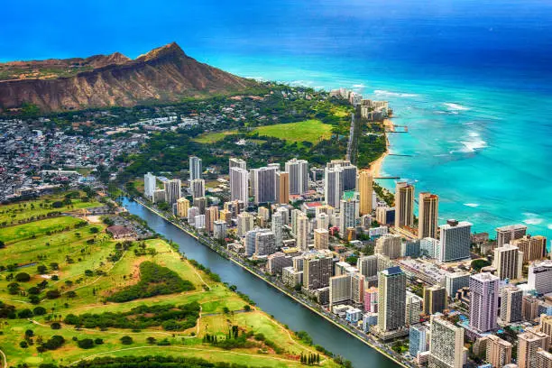 The beautiful coastline of the Waikiki area of Honolulu Hawaii with the volcanic crater, Diamond Head, in the background shot from an altitude of about 1000 feet during a helicopter photo flight over the island.