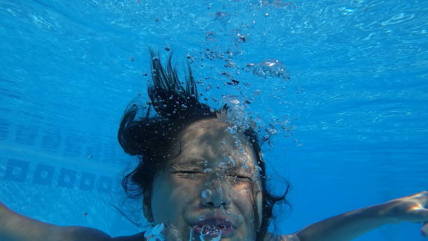 istock Girl making bubbles in her water 810335976