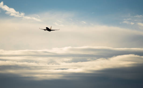 istock Silhouette airplane flying in the sky surround by blue cloud 810335996