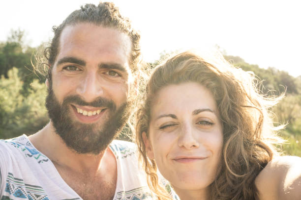istock Young couple taking a selfie and winking 810340740
