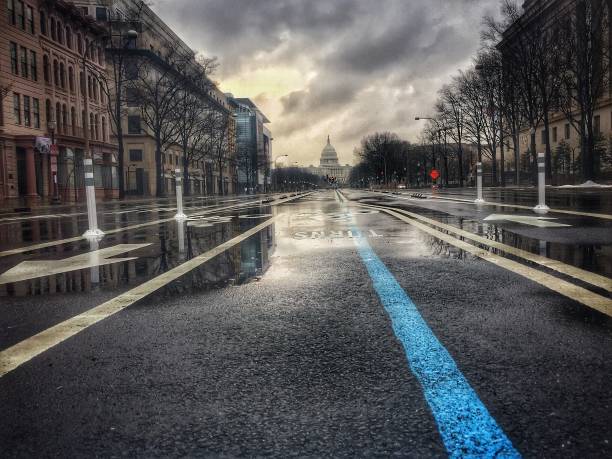 US Captiol from Pennsylvania Avenue In the morning before an Inauguration, Pennsylvania Ave damp with rain shows the blue line of the parade route from the United States Capitol Building, in Washington DC. inauguration into office photos stock pictures, royalty-free photos & images