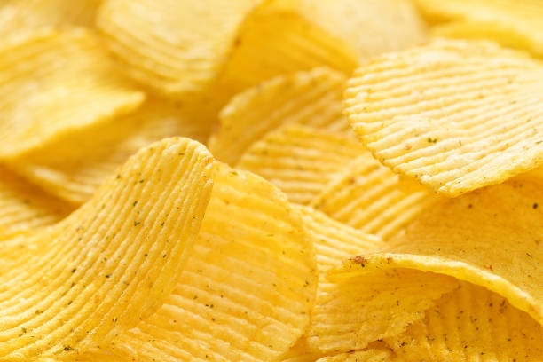 istock Yellow salted potato chips as background, closeup 810444328