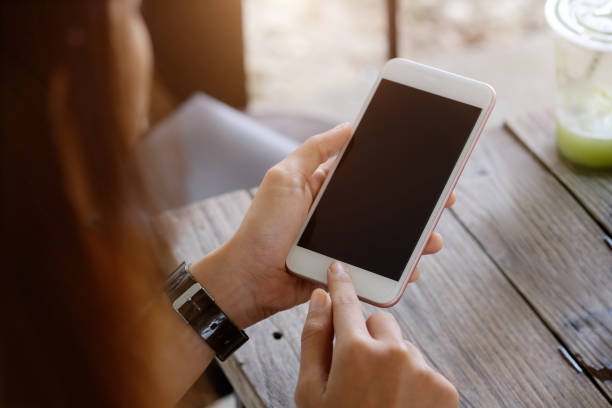 istock young woman sitting at a table with a coffee using mobile phone. 810444498