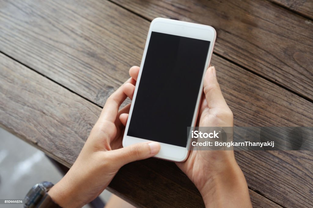 young woman sitting at a table with a coffee using mobile phone. Top view : young woman sitting at a table with a coffee using mobile phone. Telephone Stock Photo
