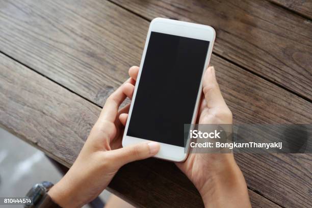 Young Woman Sitting At A Table With A Coffee Using Mobile Phone Stock Photo - Download Image Now