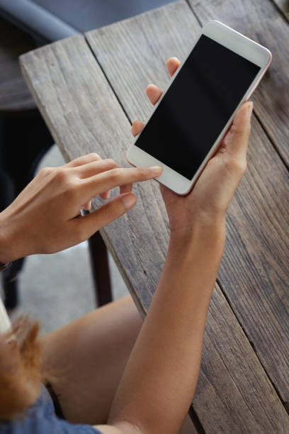 istock young woman sitting at a table with a coffee using mobile phone. 810444518