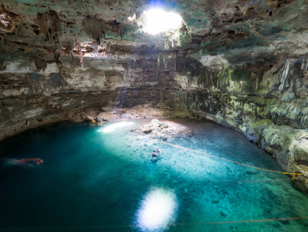 istock Young man swimming in cenote Samula in mexico 810464216