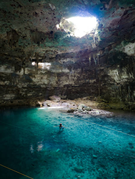 istock Young man swimming in cenote Samula in mexico 810464236