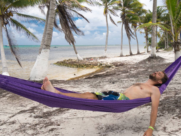 istock Young man lying in hammock on caribbean paradise beach 810464238