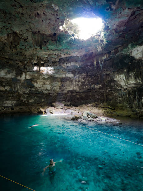 istock Young man swimming in cenote Samula in mexico 810464280