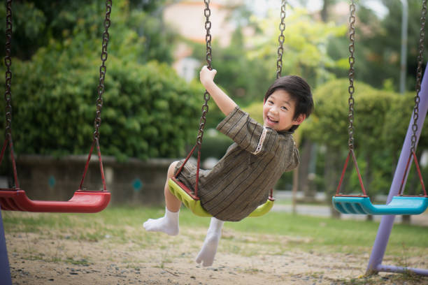 istock Asian child in kimono playing on swing i 810469272