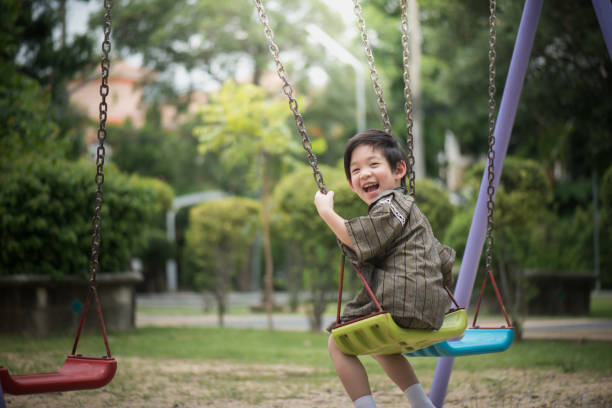 istock Asian child in kimono playing on swing i 810469304