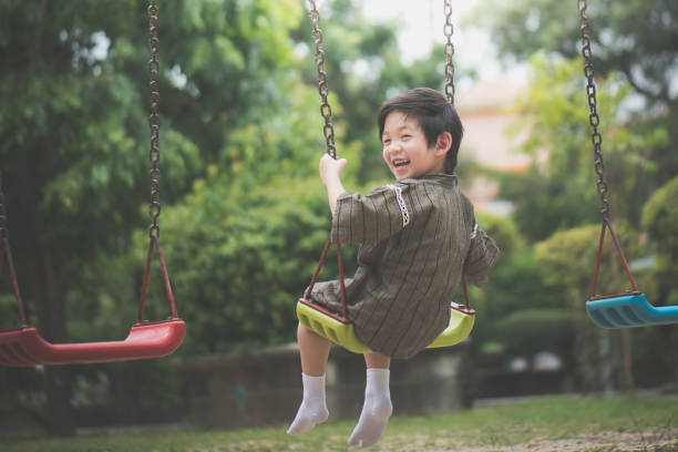 istock Asian child in kimono playing on swing i 810469336