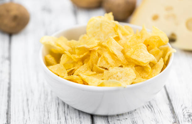 istock Portion of Potato Chips (Cheese and Onoion taste) on wooden background (selective focus) 810486452