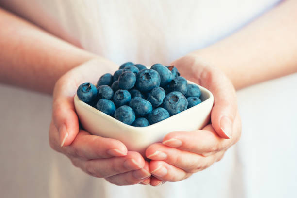 istock Woman offering blueberries 810494626