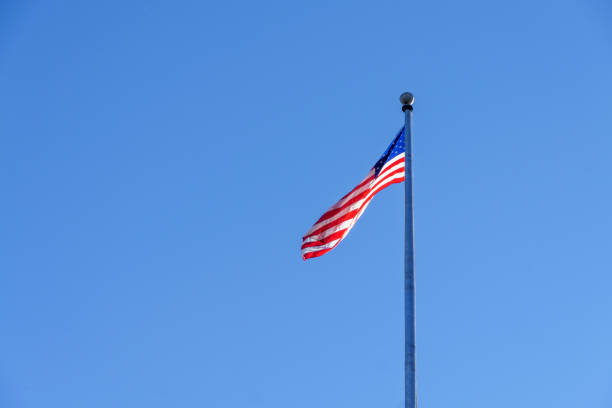 istock American flag in blue sky 810502872