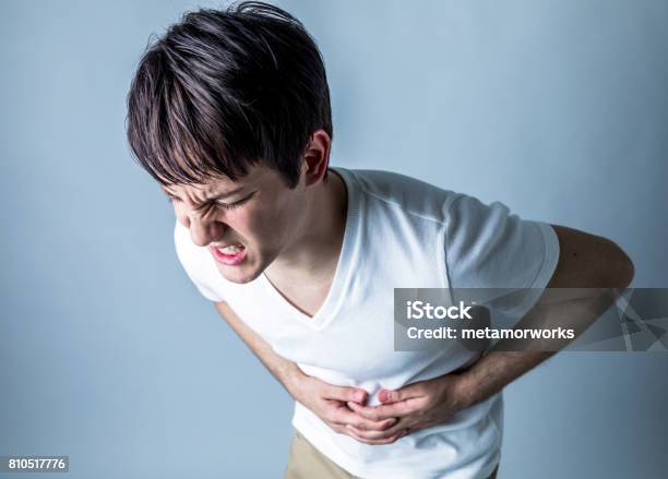 Young Man Having A Stomachache Stock Photo - Download Image Now - Stomachache, Food Poisoning, Men