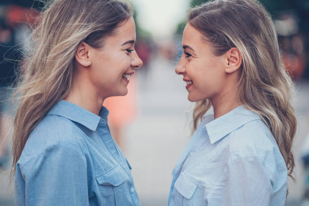 istock Close side view of smiling sisters 810526950