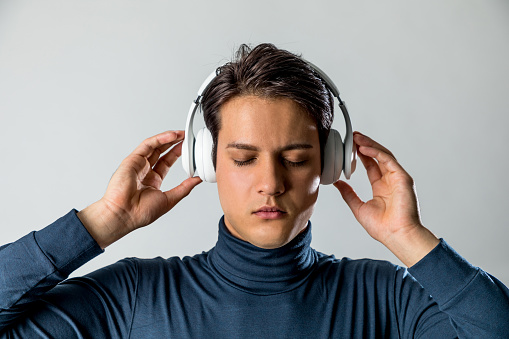young man listen to the music with wireless headphone