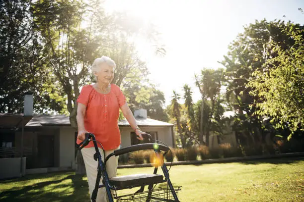Shot of a happy senior woman going for a walk in the garden with a walker