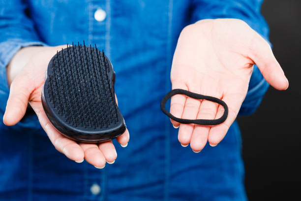 istock Female hands with comb and elastic hair. 810543056