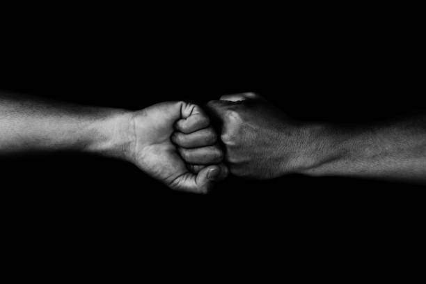 istock two fists hitting each other over dark in white tone 810547186