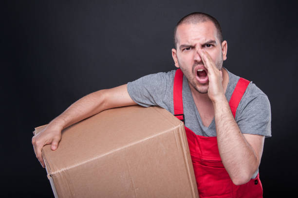 istock Mover man holding box and screaming loud 810552758